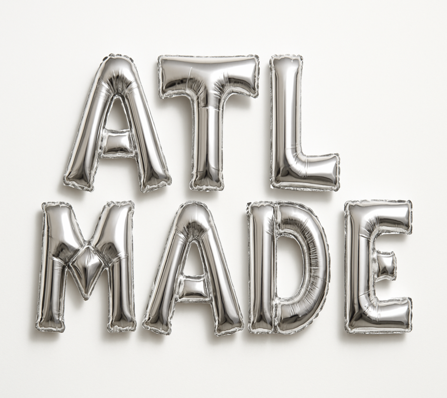 ATL MADE in silver foil letter balloons on white background. All letters should be the same size with no strings.
