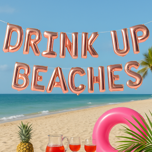 Rose gold 'Drink Up Beaches' balloon banner with a beach scene featuring a pineapple, drinks, and an inflatable ring.