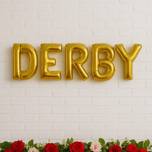 Gold letter balloons spelling 'DERBY' against a white brick wall with red and pink roses at the bottom.