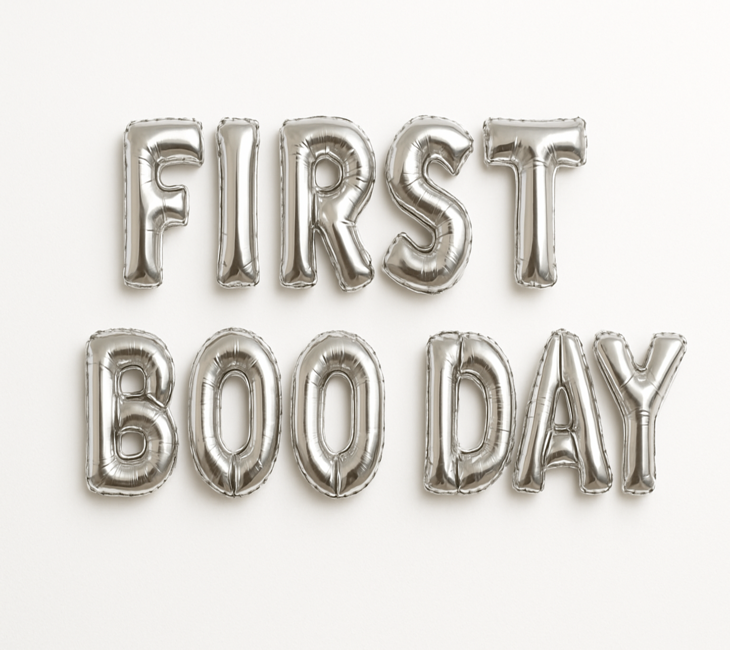 Silver balloon letters spelling 'FIRST BOO DAY' on a white background
