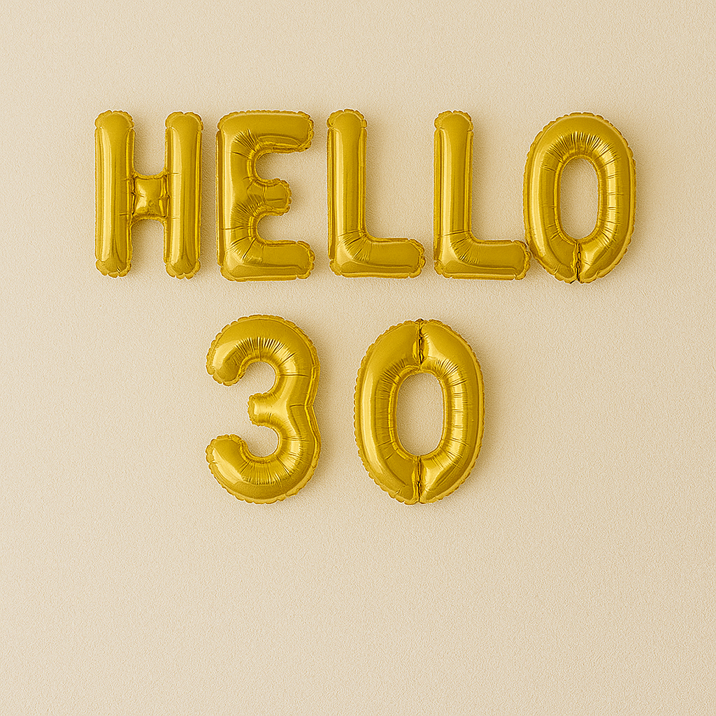 Gold 'HELLO 30' balloons on a beige background