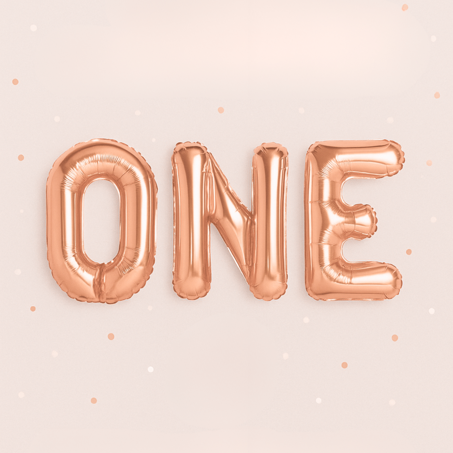 Rose gold 'ONE' balloon set on a light pink background