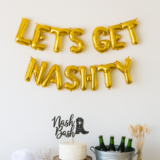 Gold letter balloons spelling 'LET'S GET NASHTY' on a white wall with a 'Nash Bash' decorative item.