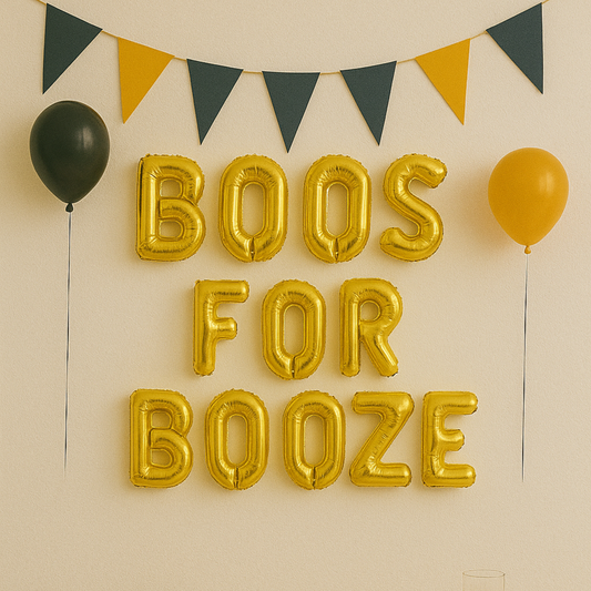 Gold balloon letters spelling 'BOOS FOR BOOZE' with black and yellow triangular flags and balloons on a beige wall.