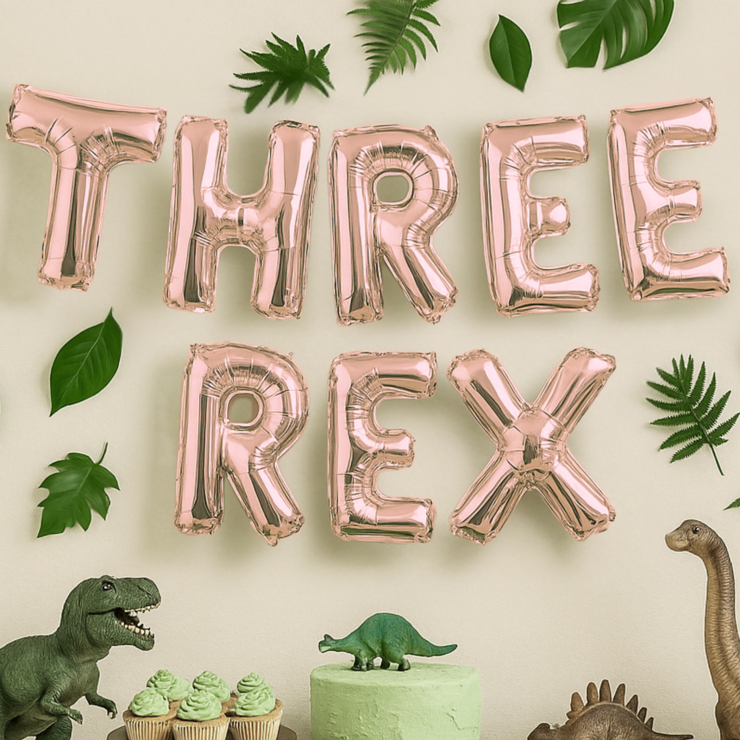 Rose gold 'THREE REX' balloons with dinosaur-themed decor on a light background