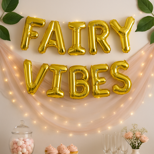 Gold 'FAIRY VIBES' balloons with fairy lights and decorative items on a light background