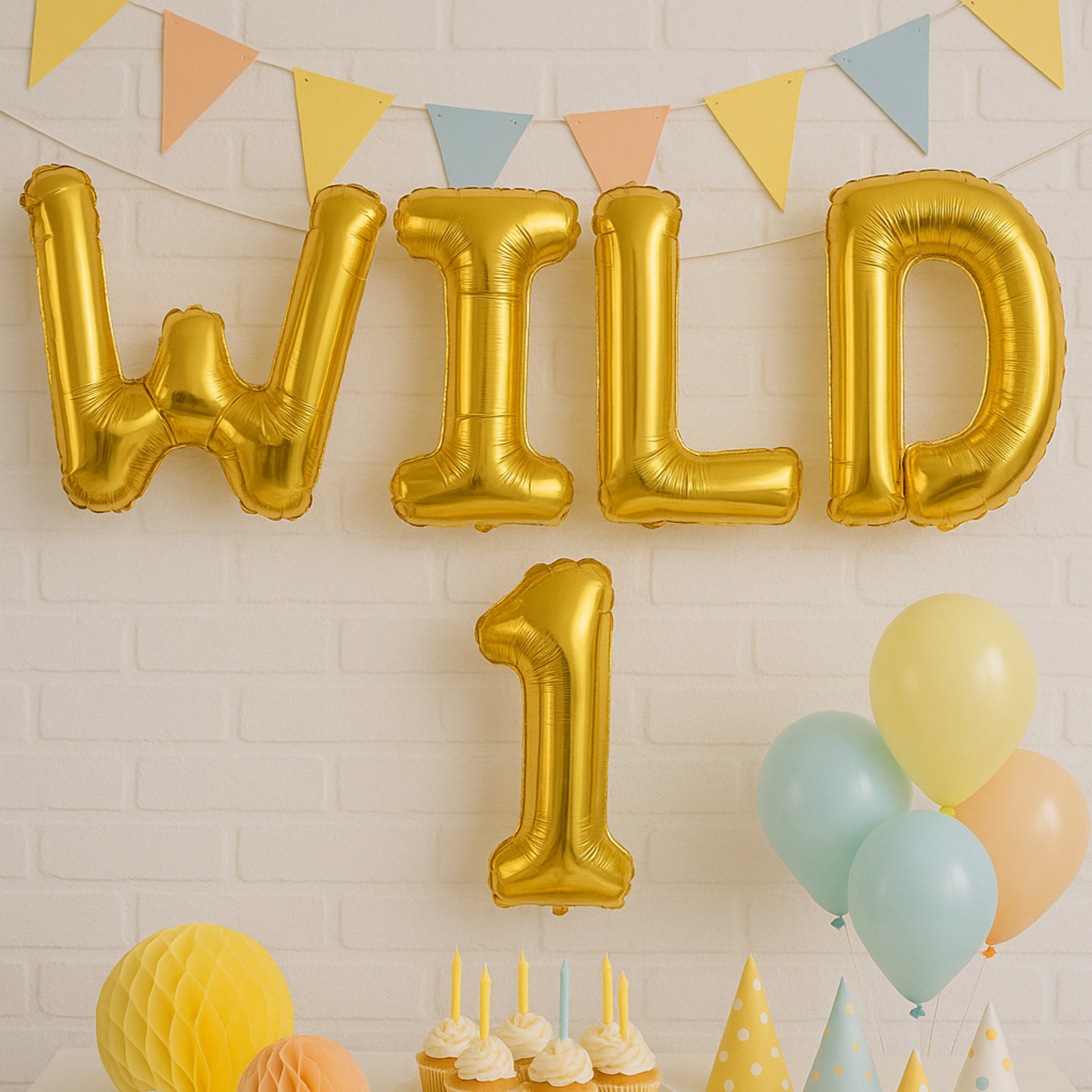 Gold 'WILD 1' balloons with colorful balloons and decorations on a light brick wall background.