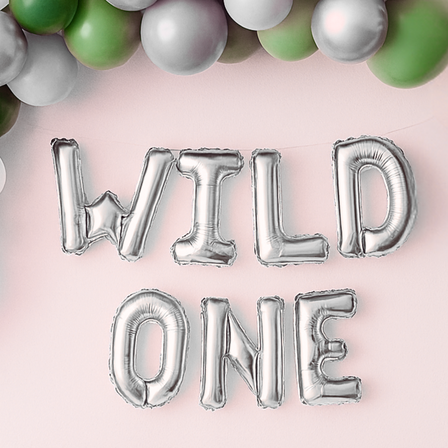 Silver 'WILD ONE' balloons on a pink background with colorful balloons at the top.