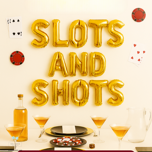 Slots and Shots gold foil letter balloons arranged on a wall for a casino-themed party.