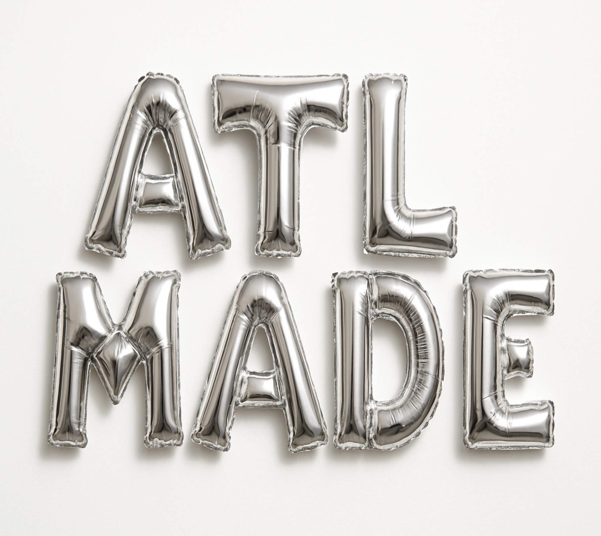 ATL MADE in silver foil letter balloons on white background. All letters should be the same size with no strings.
