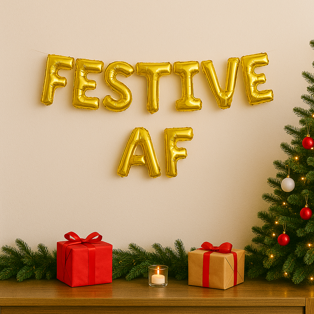 Gold 'Festive AF' balloons on a wall with Christmas decorations including a tree, presents, and a candle.