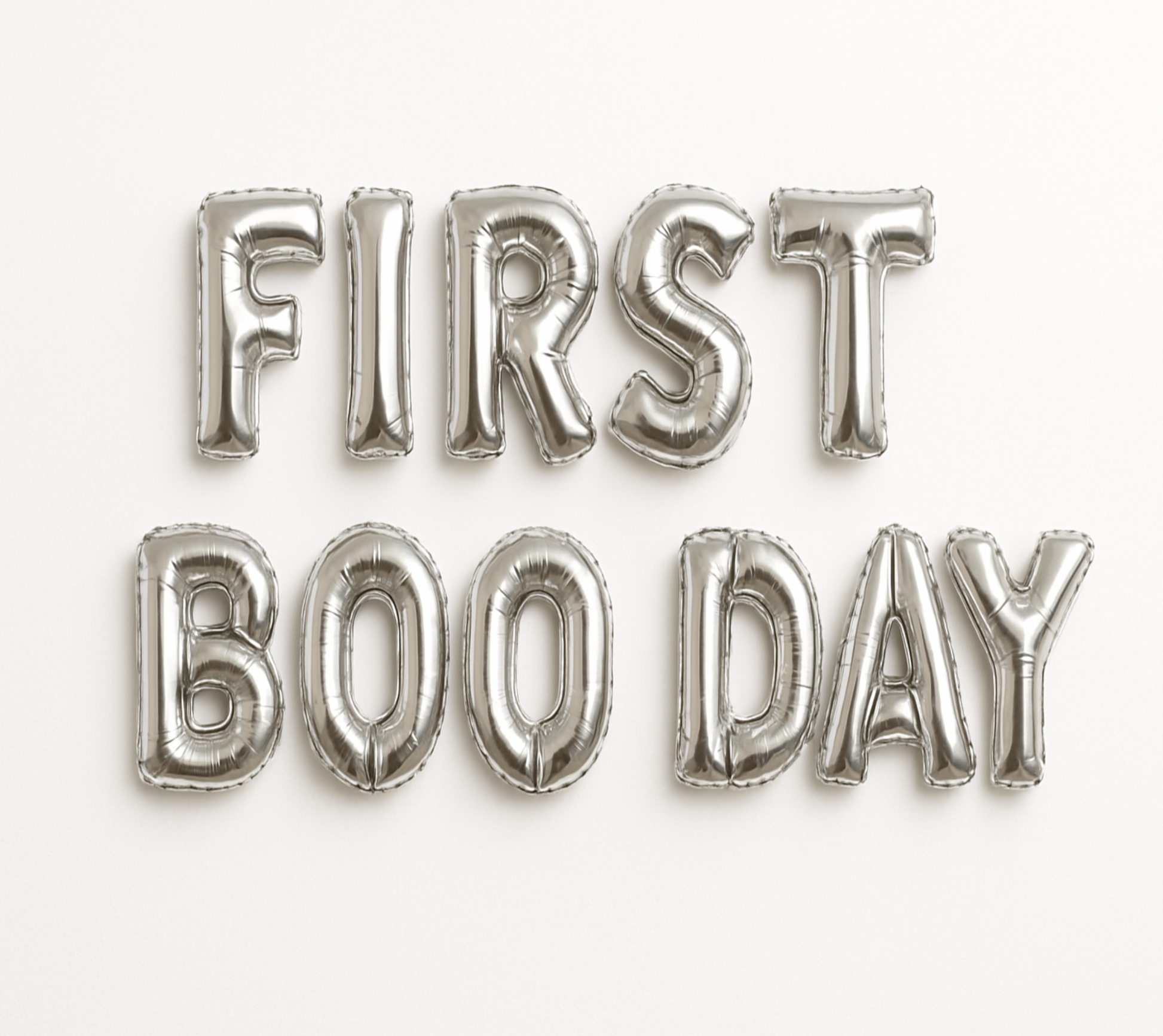 Silver balloon letters spelling 'FIRST BOO DAY' on a white background