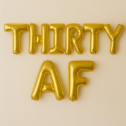 Gold inflatable balloons spelling 'THIRTY AF' on a beige background