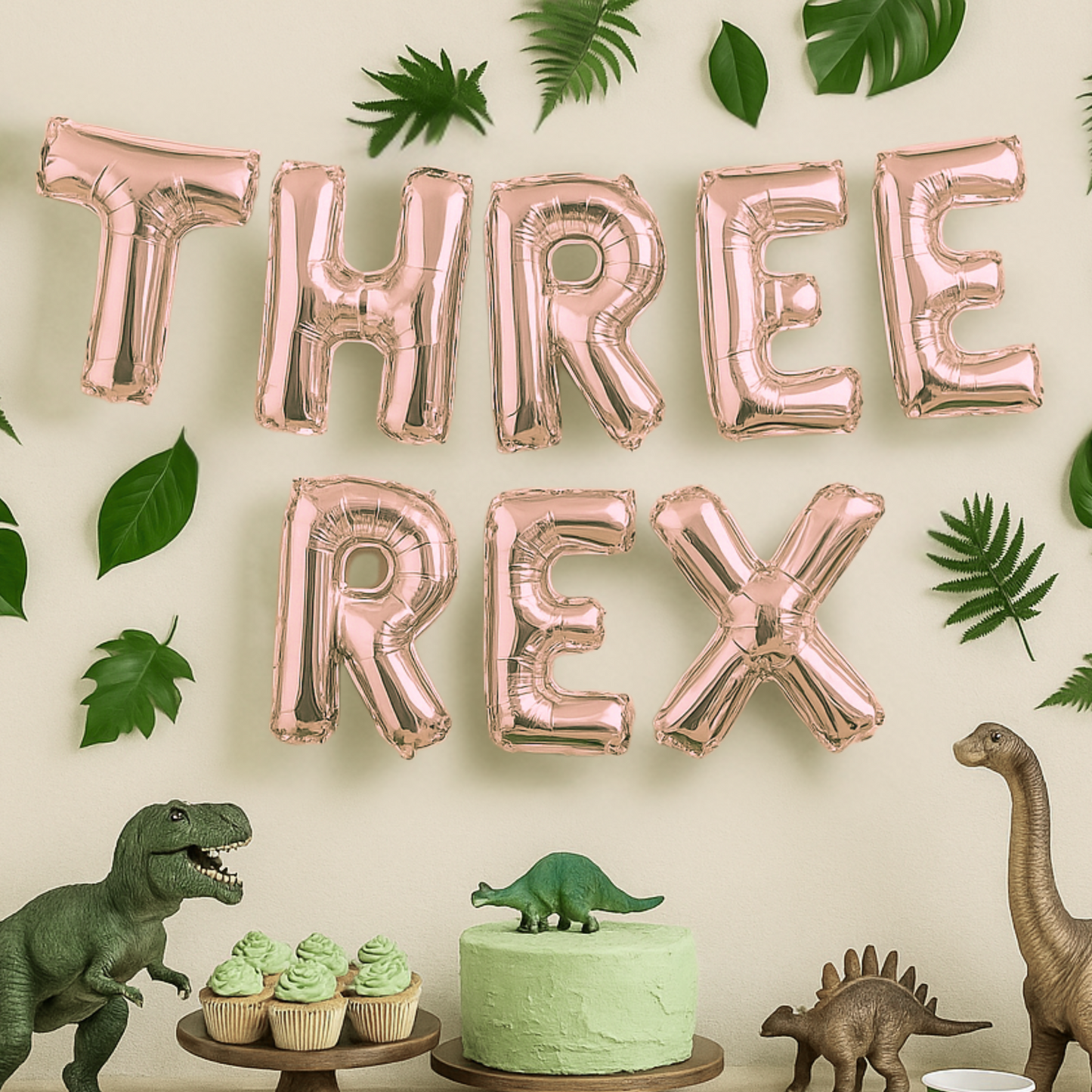 Rose gold 'THREE REX' balloons with dinosaur-themed decor on a light background