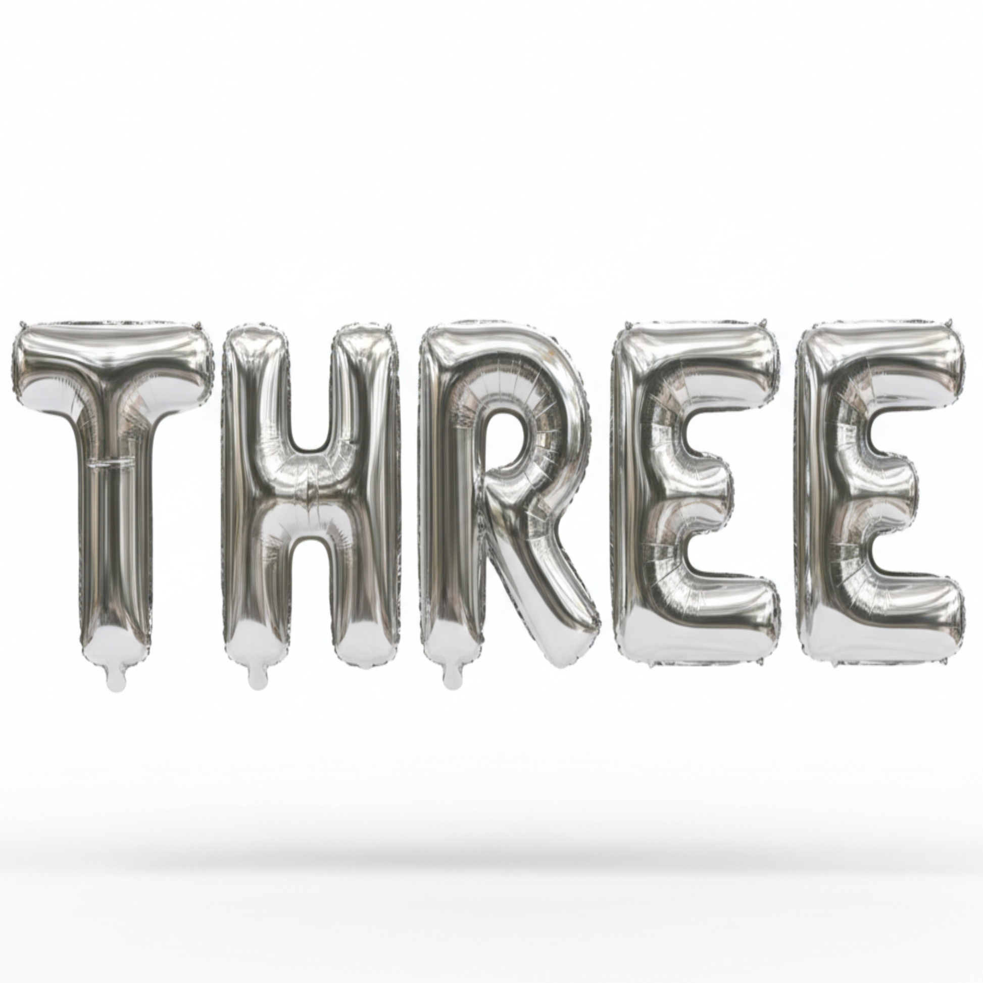 THREE in silver foil letter balloons on white background. All letters should be the same size with no strings.